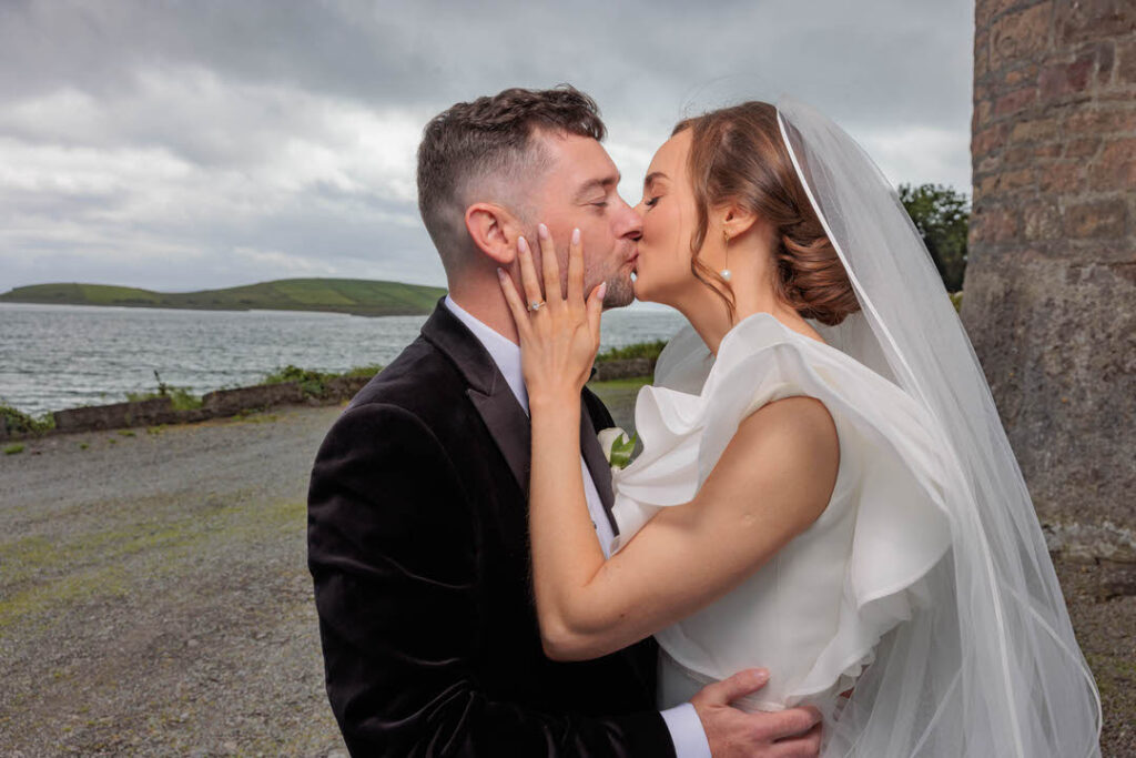 Bride kissing groom passionately at rosturk castle Mulranny Wedding of Aisling and Luke